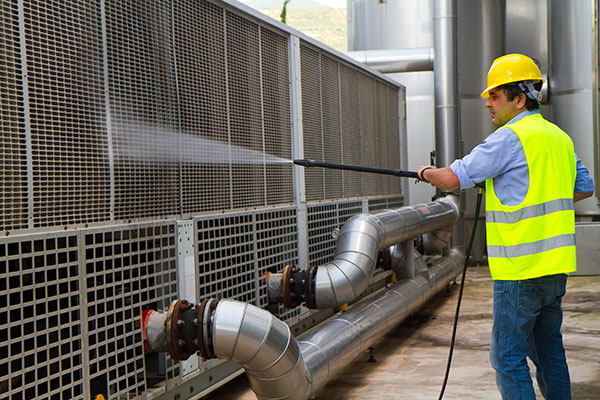pracownik GB Clean podzczas czyszczenia maszyny przemysłowej